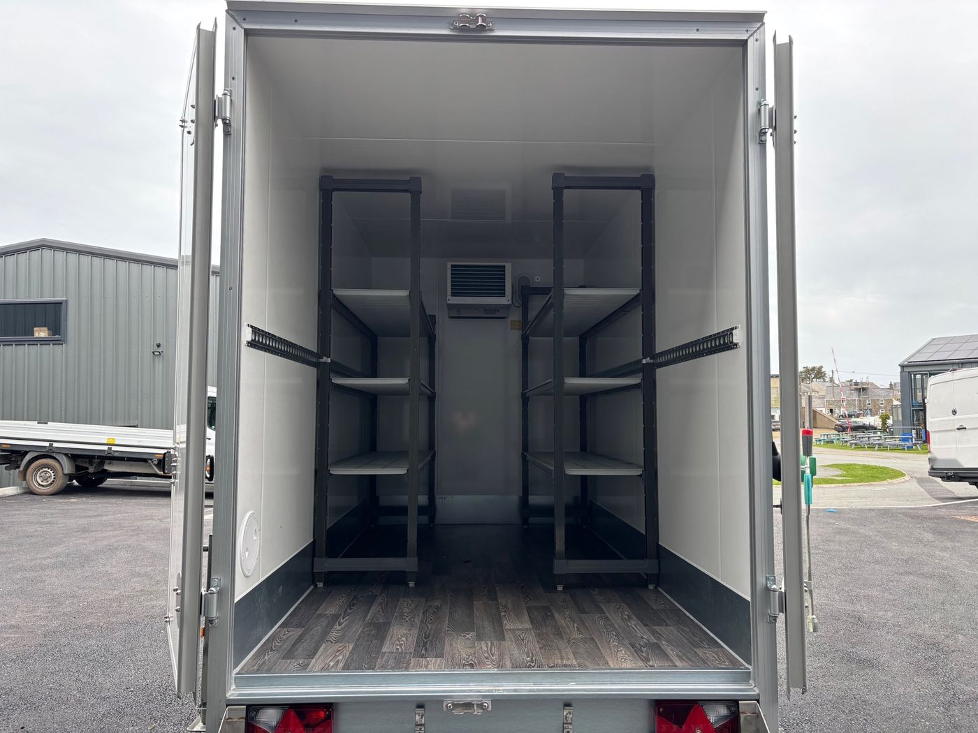Inside the fridge trailer: two bays of Cambro shelving either side of the cooling unit