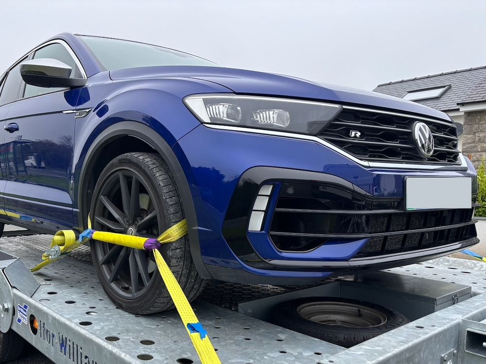 Blue VW T-Roc strapped at the wheels on the car transporter