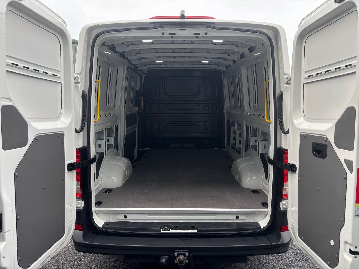 The Crafter's rear doors open, showing the empty lined load space and tow bar